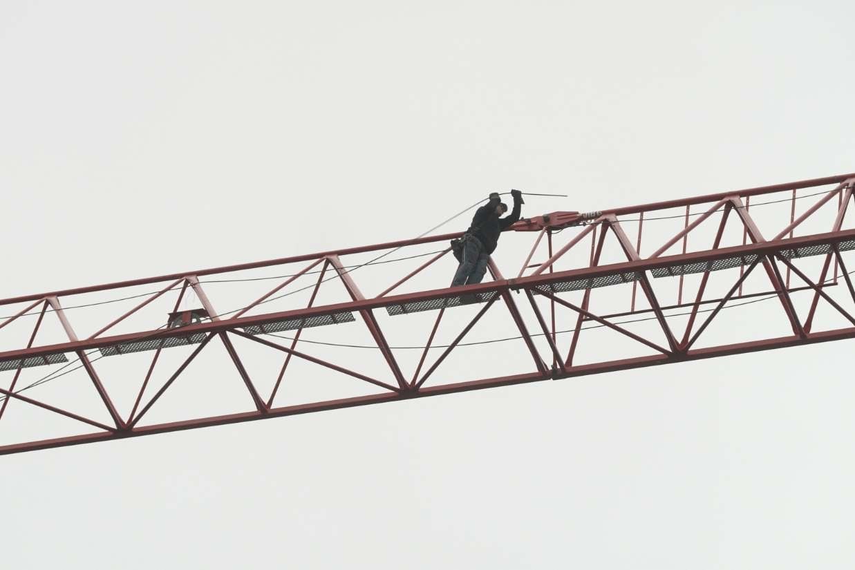 Construction worker walks up to crane control deck.