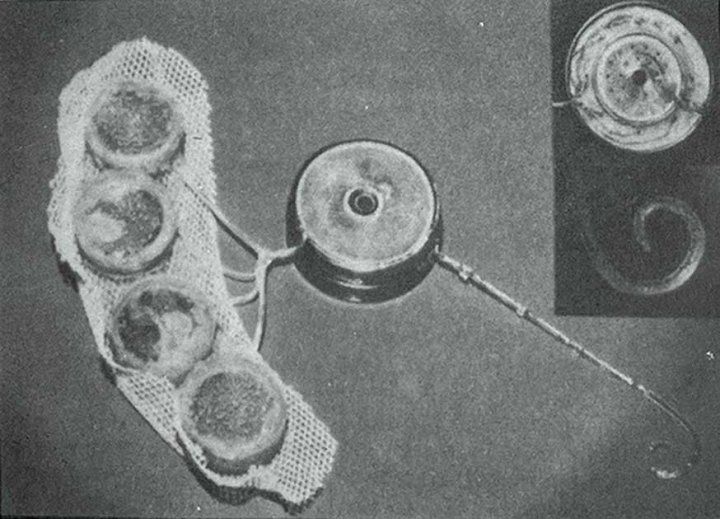 A black and white photo of an early prototype of the implantable components of a cochlear device.